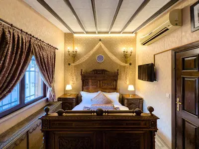 a bedroom with a large wooden bed in a room at Antik Konak Little Hagia Sophia Suites in Istanbul