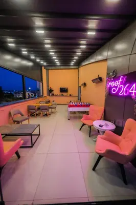 a waiting room with tables and chairs and a neon sign at Roof 264 Hotel & Suites in Sakarya