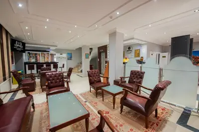a waiting room with chairs and tables and a fireplace at GRAND VATAN HOTEL in Istanbul