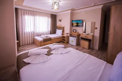 a hotel room with two beds and a television at Hotel Orkide in Istanbul