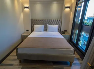 a bedroom with a large bed with two windows at Mardia Hotel in Istanbul