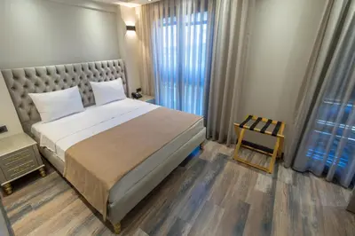 a bedroom with a large bed and a chair at Mardia Hotel in Istanbul