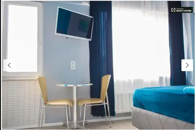 a bedroom with a table and two chairs and a tv at Blue Apartment in Istanbul