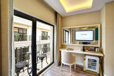 a room with a desk and a television and a balcony at Great Fortune Design Hotel & Spa in Istanbul