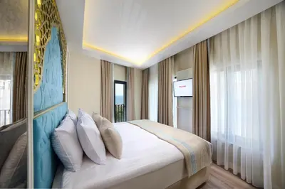 a bedroom with a bed with white sheets and pillows at Great Fortune Design Hotel & Spa in Istanbul
