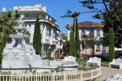 a fountain in a park with white chairs and buildings at Ararat Apart in Istanbul
