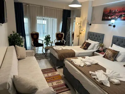 a hotel room with two beds and a couch at Galapera Hotel in Istanbul