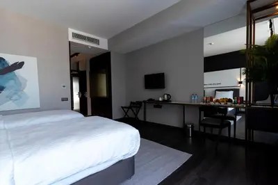 a bedroom with a bed and a desk and a mirror at Hotel Bonvie in Sakarya