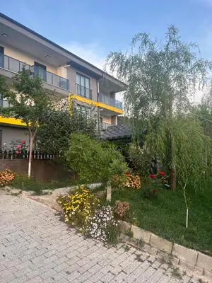 a garden in front of a building with flowers at Golden Hour Apartment بورصة شقة مريحة Bursa Nilufer مَنْظَرٌ جَمِيلٌ in Nilüfer