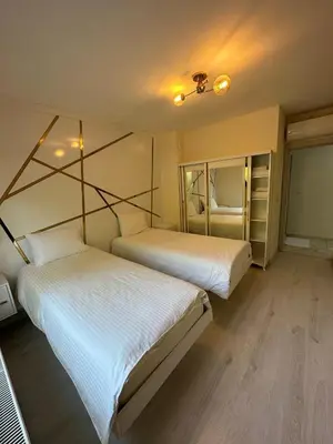 two beds in a room with white sheets at Golden Hour Apartment بورصة شقة مريحة Bursa Nilufer مَنْظَرٌ جَمِيلٌ in Nilüfer