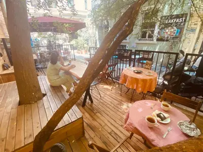 a woman sitting at a table on a wooden deck at Siesta Premium Hotel in Istanbul