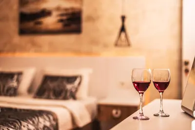 two glasses of red wine sitting on a table in a bedroom at Galata Door Hotel in Istanbul