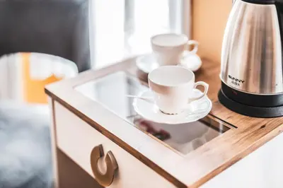 a glass cabinet with two cups and a coffee maker on it at Galata Door Hotel in Istanbul