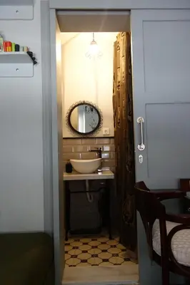 a bathroom with a sink and a mirror at Tilas - Rooms in 19th Century Wooden Townhouse,Kadikoy in Istanbul