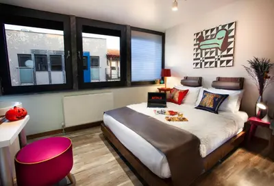 a bedroom with a large bed with a pink stool at Duo Galata Hotel in Istanbul