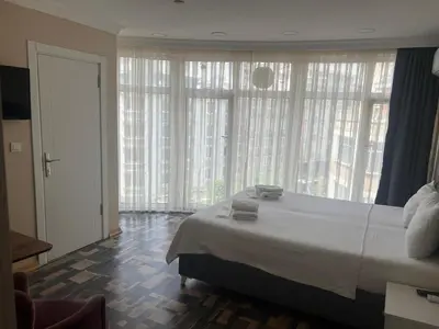 a bedroom with a large bed and large windows at King Istanbul Hotel in Istanbul