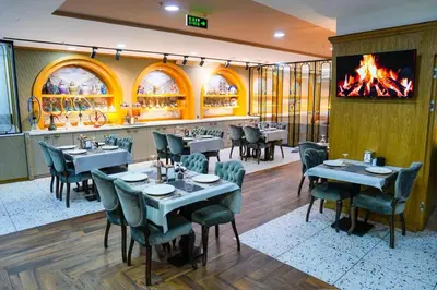 a restaurant with tables and chairs and a fireplace at İstport Hotels in Arnavutköy
