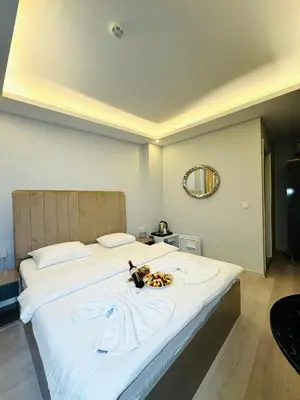 a large white bed with a plate of food on it at Blueway Hotel Istanbul Bakırköy City Center in Istanbul