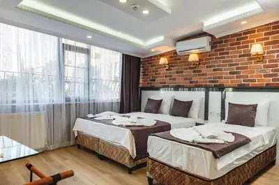 two beds in a room with a brick wall at Gloria Suites Old City in Istanbul