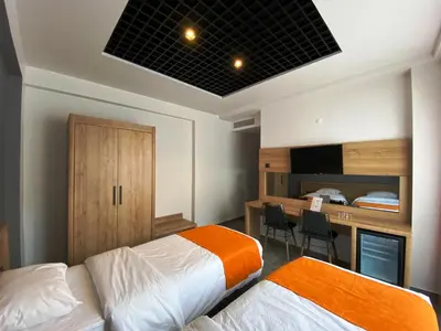 a hotel room with two beds and a desk and a desk at MOPE Hotel in Tekirdag