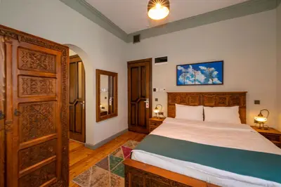 a bedroom with a large bed and a wooden door at O'Pera Okanlı Suites in Istanbul