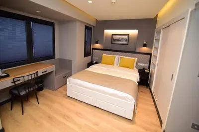 a bedroom with a bed with yellow pillows and a desk at The Row Taksim Hotel in Istanbul
