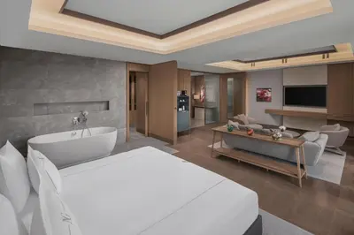a bedroom with a white bed and a living room at NG Enjoy in Sapanca