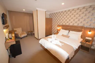 a hotel room with a large bed and a chair at Arsisa in Avcılar