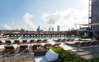 a pool on the roof of a building with lounge chairs at Hilton Istanbul Bomonti in Istanbul