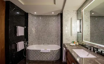 a bathroom with a tub and a sink and a mirror at Hilton Istanbul Bomonti in Istanbul