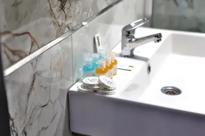 a white bathroom sink with bottles of liquid at Fly And Stay Airport Hotel in Istanbul