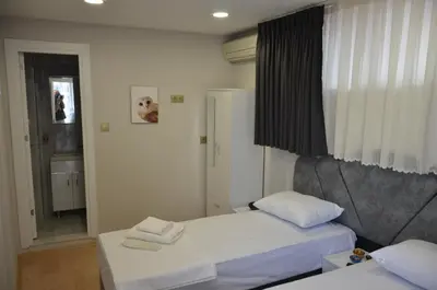 a small room with two beds and a window at Rodion Hotel in Istanbul