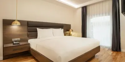 a bedroom with a large white bed and a window at The Rooms Nisantasi in Istanbul