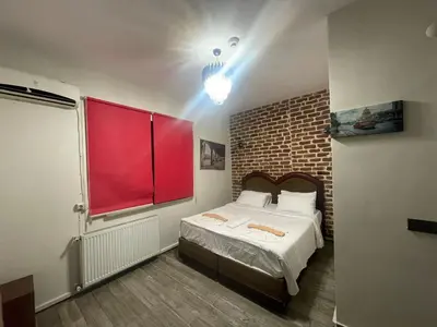 a bedroom with a large bed with a red window at GRAND BELLA VİSTA Hostel in Istanbul