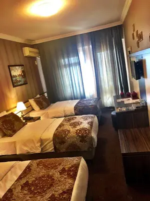a hotel room with three beds and a window at Family Resort Hotel in Selimpasa