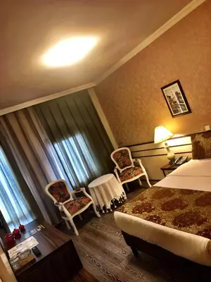 a hotel room with a bed and two chairs at Family Resort Hotel in Selimpasa