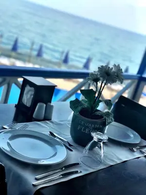 a table with plates and utensils and a potted plant on it at Family Resort Hotel in Selimpasa