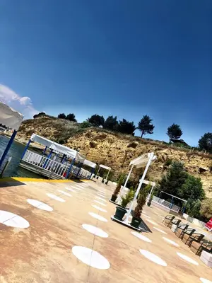 a empty pier with a building on a hill at Family Resort Hotel in Selimpasa