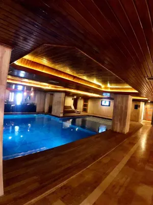 a large swimming pool in a building with a wooden ceiling at Family Resort Hotel in Selimpasa