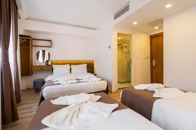 a hotel room with three beds with towels on them at Castillo Rojo Hotel Istanbul in Istanbul