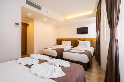 a hotel room with four beds with white sheets at Castillo Rojo Hotel Istanbul in Istanbul