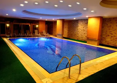 a large swimming pool in a hotel with chairs around it at İğneada Resort Hotel & SPA in Igneada