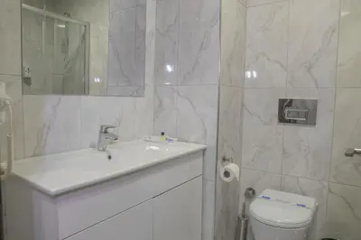 a white bathroom with a sink and a toilet at Sakarya Hotel in Sakarya