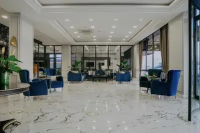 a lobby with blue chairs and tables and windows at Sakarya Hotel in Sakarya