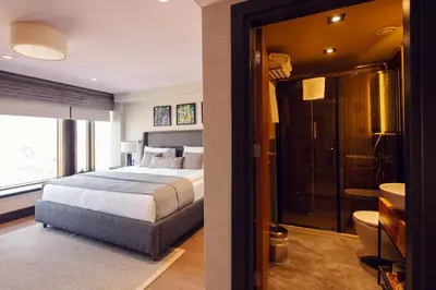 a bedroom with a bed and a bathroom with a shower at Root Hotel Karaköy Bosphorus in Istanbul
