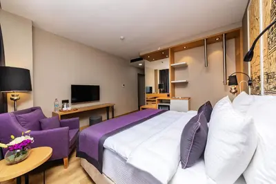 a hotel room with a large bed and purple furniture at The Halich Hotel Istanbul Karakoy - Special Category in Istanbul