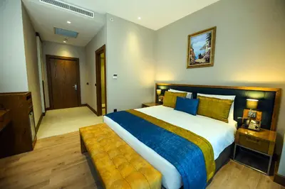 a bedroom with a large bed with a yellow and blue blanket at CHER HOTEL & SPA Taksim in Istanbul