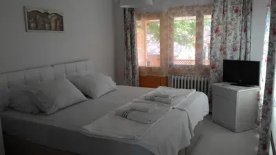 a bedroom with a white bed and a television at Zumrut Bahce in Gokcedere
