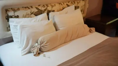 a bed with white pillows and a blanket on it at Treetops Park Hotel in Sile