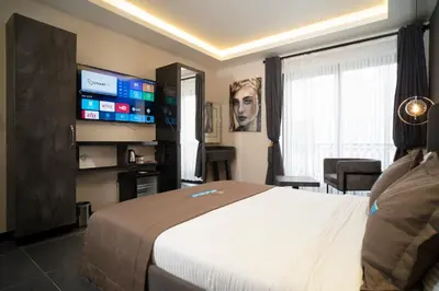 a hotel room with a bed and a flat screen tv at La Cielo Hotel Bostancı in Istanbul